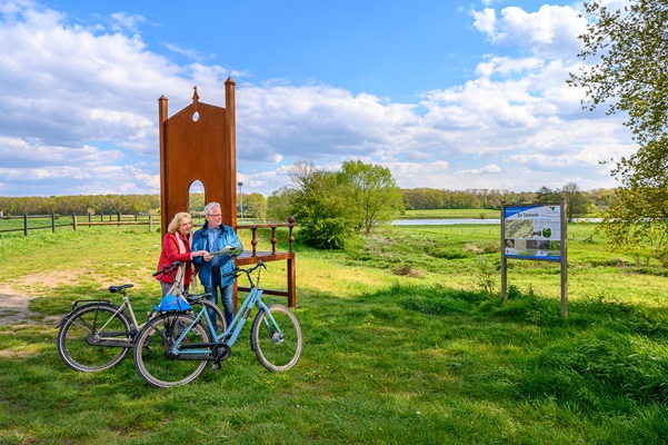 Woman and man look at the map at the large artwork on the River Meuse in Kessel