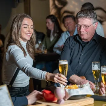 Bezoekers genieten van een drankje in Hornerhof Poolbar in Horn, een gezellige locatie voor uitgaan in Limburg.